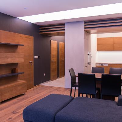Realizácia dreveného interiériu obývacej izby kombinovanej s kuchyňou a predsieňou.